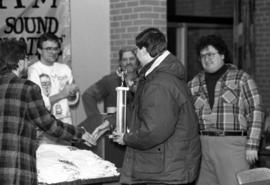 A man is handed a trophy during the KVSC trivia weekend closing ceremonies, St. Cloud State University