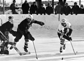 Hockey player Paul Oberstar skates with a puck, St. Cloud State University