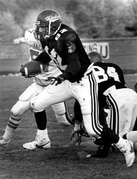 Football player Brent Otto runs with a football against the University of South Dakota, St. Cloud State University