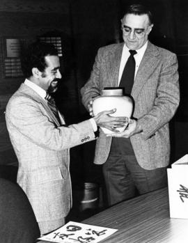 Amade Habte gives acting president Lowell "Ted" Gillett a Japanese vase, St. Cloud State