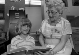 Woman reads to a book to a child, St. Cloud State University