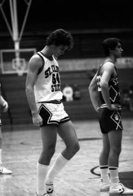 St. Cloud State University basketball player Dan Hagen stands on a basketball court during a break in the action in a game against St. Thomas University