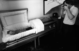 Allen Stensland photographs student Diane Riskevich in a casket, St. Cloud State University