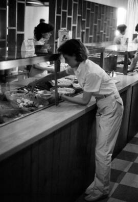 Woman serves herself food at Garvey Commons (1963), St. Cloud State University