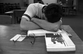 Student sleeps in Centennial Hall (1971) during finals week, St. Cloud State University