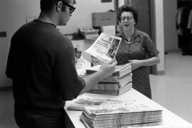 Man reads a copy of the Chronicle newspaper, St. Cloud State University