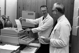 Faculty members James McMullen and Richard James look at mass spectromater results, St. Cloud State University
