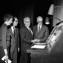 Presidents Robert Wick and George Budd, Emily Hannah, and Roger Barrett look at equipment at the Performing Arts Center (1968) dedication, St. Cloud State University