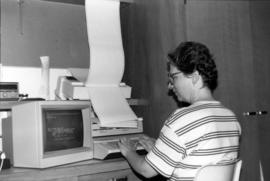 Woman sits at a computer terminal, St. Cloud State University