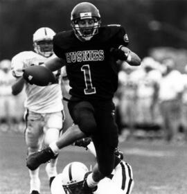 Mike McKinney runs with a football during a football game, St. Cloud State University