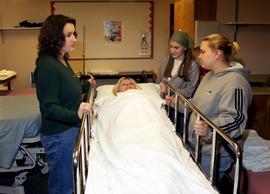 Nursing students stand at bedside, St. Cloud State University