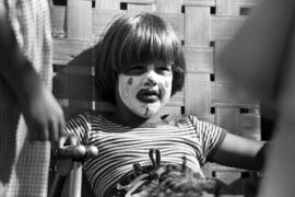 A boy sits in a chair, Lemonade Concert and Art Fair, St. Cloud State University