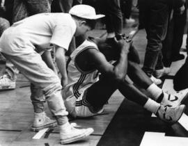 A fan comforts men's basketball player Reggie Perkins after a loss, St. Cloud State University