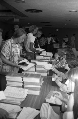 Students pick up course catalogs at freshmen orientation, St. Cloud State University