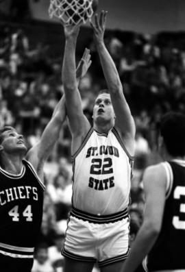 Basketball player Mark Harvey shoots a basketball during a game against Morningside College, St. Cloud State University