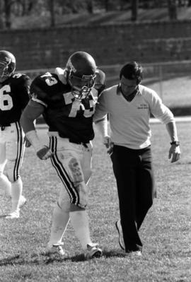 Football player Mike Lambrecht is helped off the football field in a game against North Dakota State University, St. Cloud State University