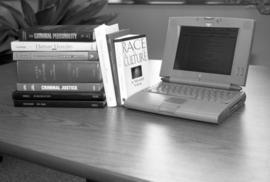 Criminal Justice books next to a laptop computer, St. Cloud State University