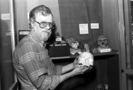 Richard Lane holds a human skull model at the Museum of Man, St. Cloud State University