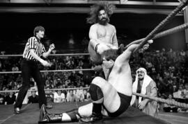 King Kong Brody fights his opponent during a wrestling match while his manager Sheik Adnan Al Kaissie looks on, Halenbeck Hall (1965), St. Cloud State University