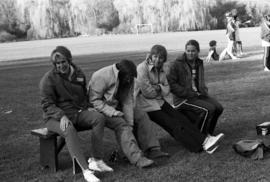 Dee Whitlock and others relax together on a bench, St. Cloud State University