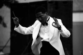 A man conducts an orchestra, Lemonade Concert and Art Fair, St. Cloud State University