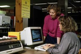 Librarian Susan Hubbs Motin helps a student in the library, St. Cloud State University