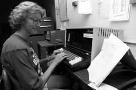 Sue Christian types into a computer at a Mass Communications workshop, St. Cloud State University