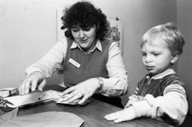 A woman works with a child, Speech Pathology, St. Cloud State University