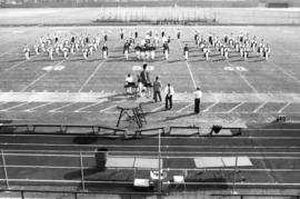 Marching band performing on a football field, St. Cloud State University