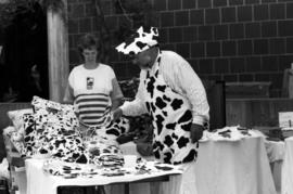 A man sorts through purses that look like cows, Lemonade Concert and Art Fair, St. Cloud State University