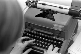 Woman uses a typewriter in the Chronicle newspaper newsroom, St. Cloud State University