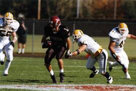 Mike McKinney runs with a football during a football game, St. Cloud State University