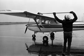 Darek Kurplus of the Aero Club sweeps snow off a plane at the National Intercollegiate Flying Association Region 5 Air Meet, St. Cloud State University