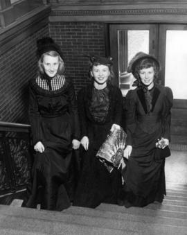 Phyllis Glaser, Mary Stark, and Gertrude Beacom, Belle of 69 homecoming candidates, stand inside of Old Main (1874), St. Cloud State University