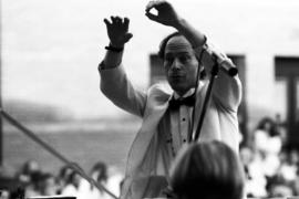 A man conducts an orchestra, Lemonade Concert and Art Fair, St. Cloud State University