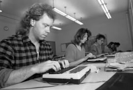 Man types at the Mass Communications laboratory, St. Cloud State University