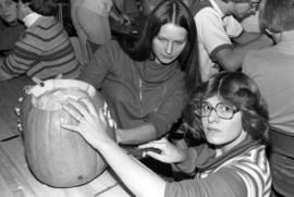 Two women carve a pumpkin at the Halloween Hullabaloo, St. Cloud State University