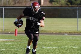 Mike McKinney runs with a football during a football game, St. Cloud State University