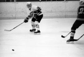 A hockey player passes the puck, St. Cloud State University