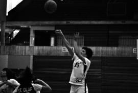 Basketball player Sue Wahl shoots a ball during a basketball against St. Olaf College at Halenbeck Hall (1965)