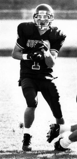 Mike McKinney runs with a football during a football game, St. Cloud State University