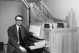 Charles Echols sits at an organ, St. Cloud State University