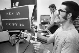 Man operates a television camera at a Communications workshop, St. Cloud State University