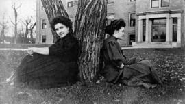 Pat Conley and Ima Parks sit in front of Lawrence Hall (1905), St. Cloud State University