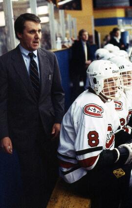 Herb Brooks coaches a hockey game behind the bench, St. Cloud State University