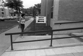 Woman walks near Health Services sign at Hill Hall (1962), St. Cloud State University