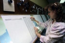 Woman works on putting the Chronicle newspaper together, St. Cloud State University