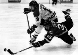 St. Cloud State University hockey player Jason Goulet battles for the puck in a hockey game against the University of North Dakota