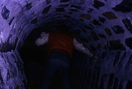 Person walking through a sewer searching for hibernating bats, St. Cloud State University