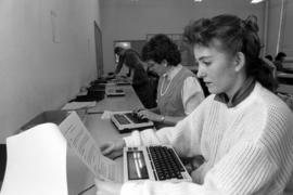 Woman reads a document at the Mass Communications laboratory, St. Cloud State University